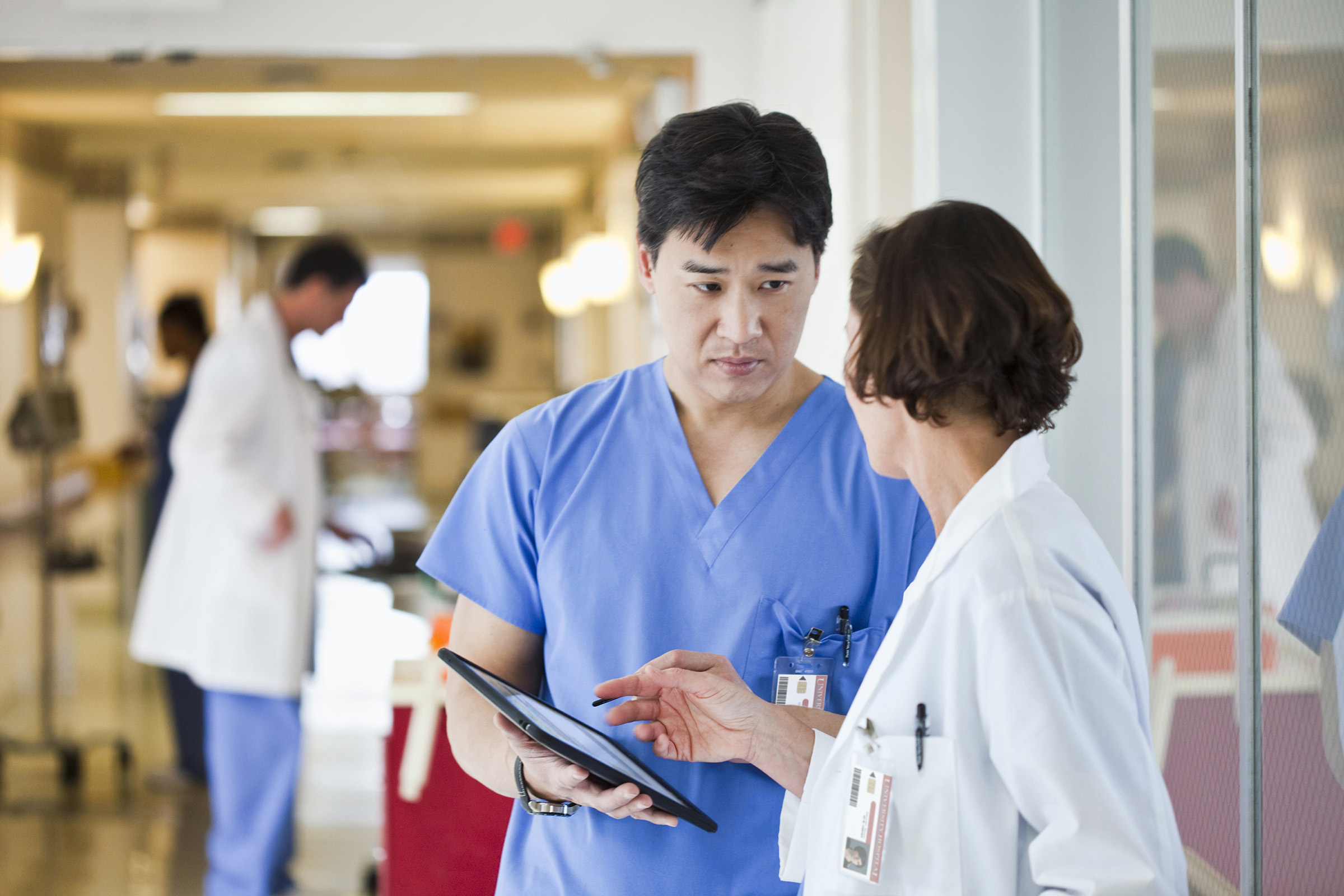 Deux cliniciens discutant sur un ecran de tablette