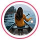 Profielfoto van reviewer, een vrouw die op roeiboot zit en een peddel vasthoudt, met het gezicht naar de zee.