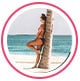 Profielfoto van reviewer, een vrouw in bikini leunend tegen een palmboom op het strand.