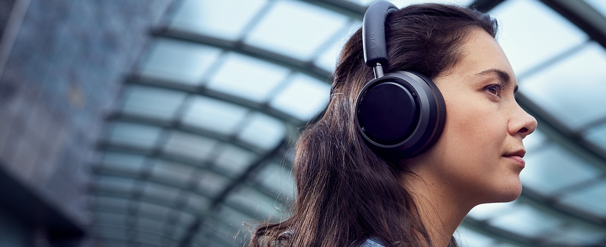 Femme écoutant de la musique en voyage à l'aide d'un casque Philips L4