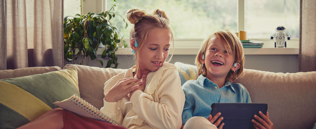 Kinderen die een video kijken met open-ear Philips-kinderkoptelefoons