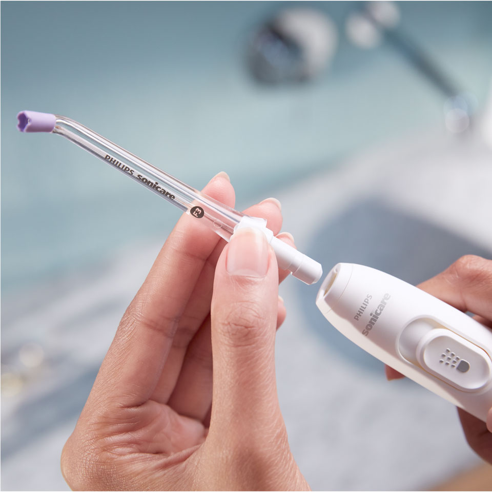 Hand bevestigt een Quad Stream-mondstuk aan de Power Flosser