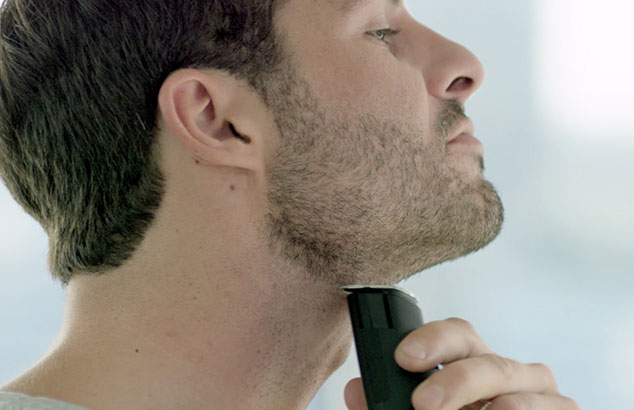 Zijprofiel van een man met korte baard die zijn nek scheert met een Philips OneBlade