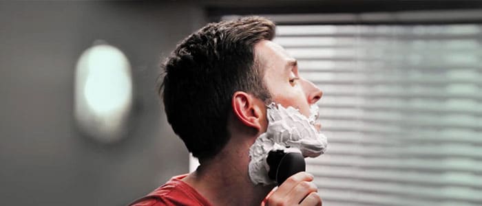 Een man met scheerschuim op zijn gezicht terwijl hij zich scheert met een Philips OneBlade