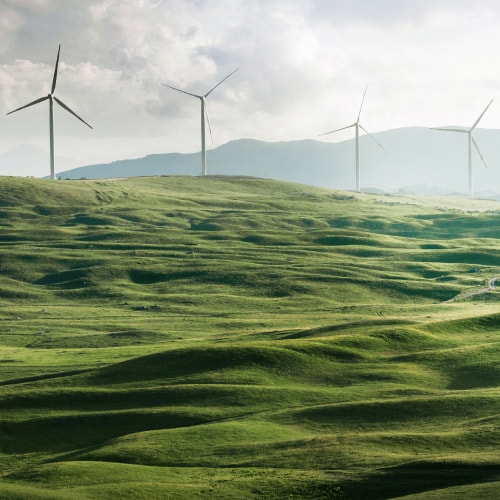 Een windmolenpark met groene heuvels, om schone energie en duurzaamheid in bedrijven voor te stellen