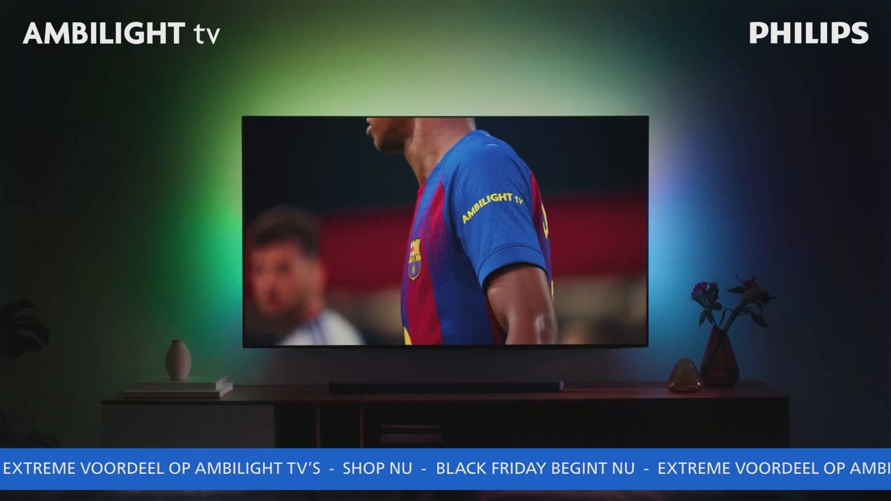 Philips Ambilight TV toont een FC Barcelona-speler in een blauw-rood shirt, met kleurrijke sfeerverlichting op de muur